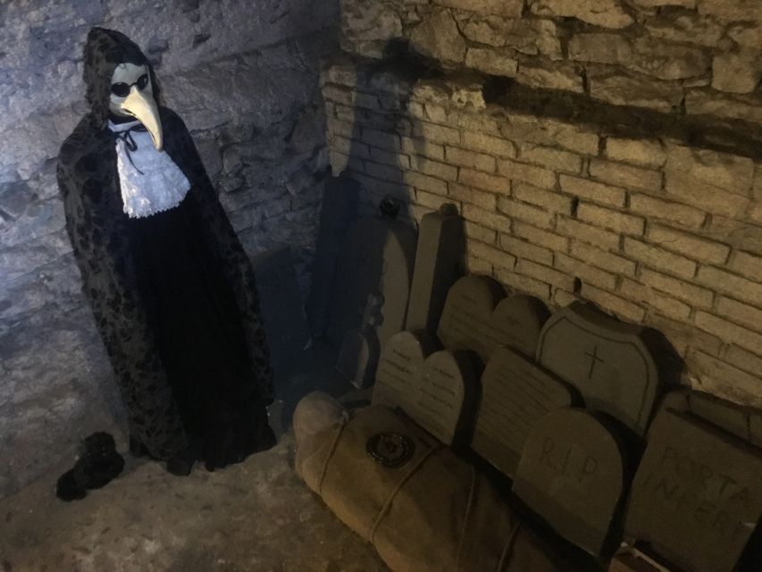 Prague: Ghosts, Legends, Medieval Underground & Dungeon Tour - Entering the candlelit dungeon